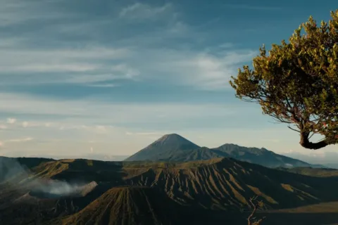 Keindahan alam wisata taman nasional Indonesia dengan pemandangan bukit hijau yang menakjubkan di bawah langit biru